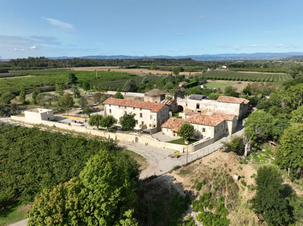 Un domaine agricole entouré de vergers près de Romans-sur-Isère, dans la Drôme, vu par drone