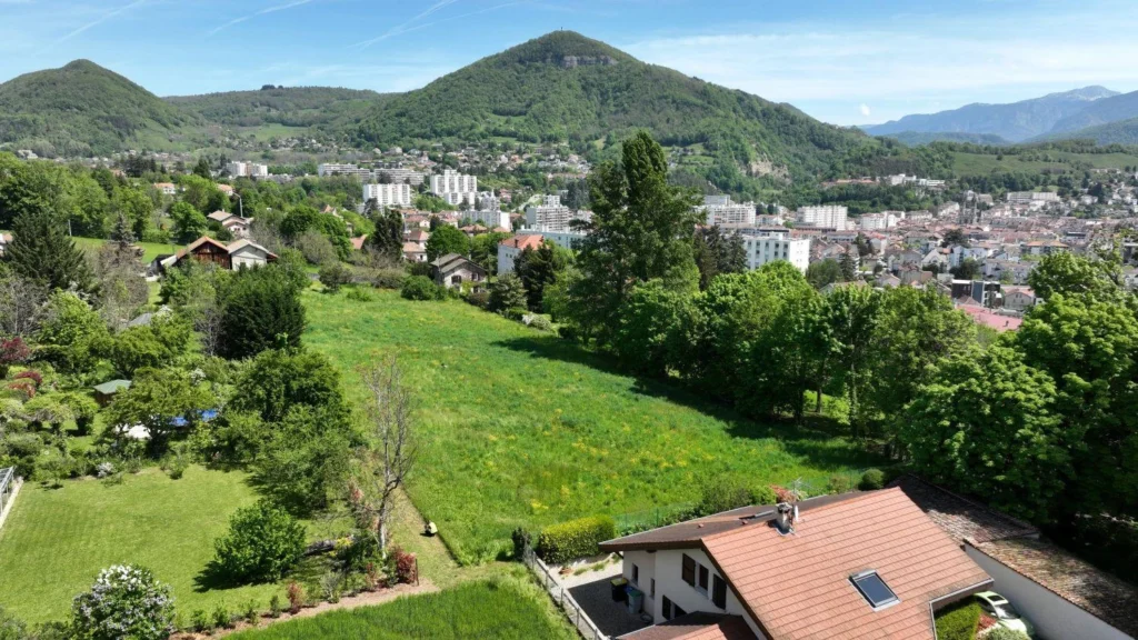 Le terrain du Domaine d’Anthyllis vu par drone, avec la ville de Voiron en contrebas et les montagnes à l’horizon