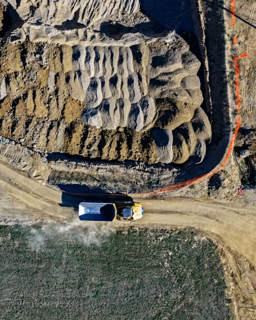 Un tombereau soulève la poussière au pied des terrassements du chantier Inspira à Sablons, vu à la verticale par drone