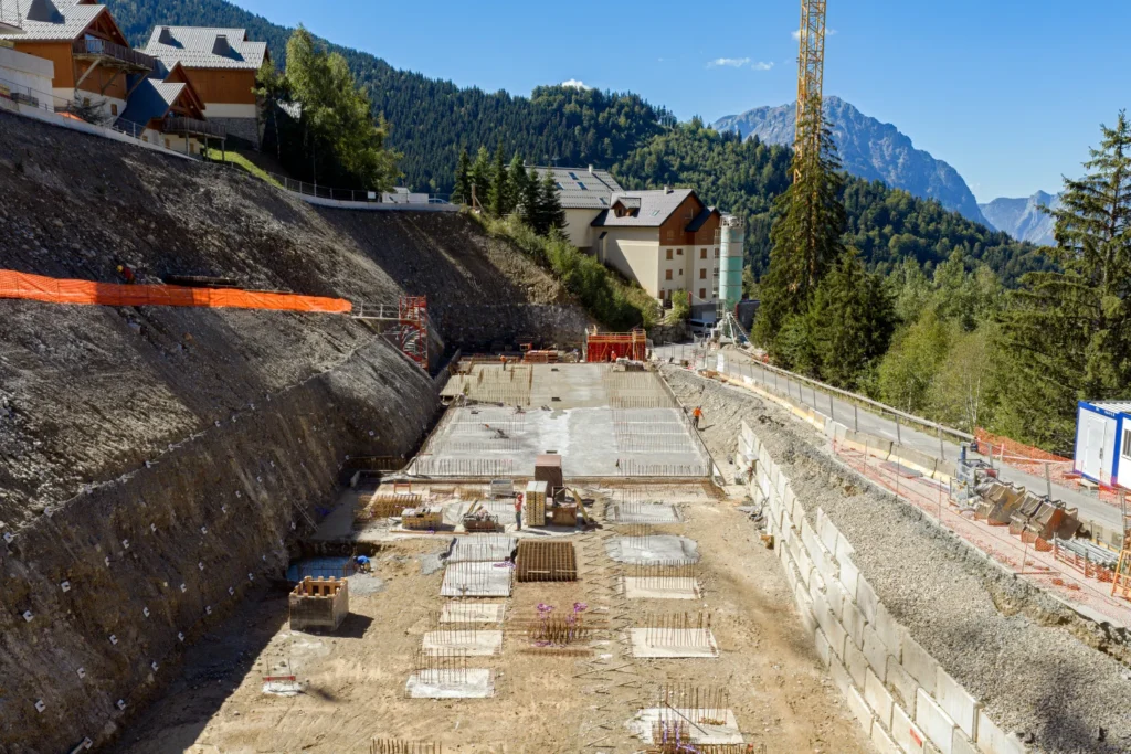Fouille du Grand Pic à Oz-en-Oisans : radier coulé et ferraillage des fondations au pied de la paroi
