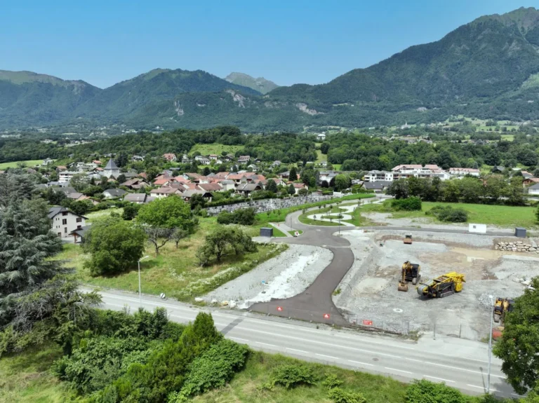 Vue de situation par drone du terrain de La Kroisée à Gilly-sur-Isère, avec sa nouvelle voirie, le village et les montagnes