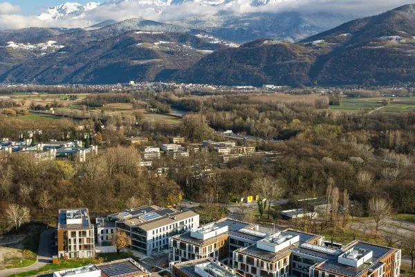 Vue aérienne par drone de Meylan avec la chaîne de Belledonne enneigée en arrière-plan